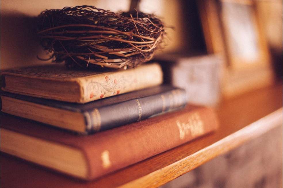 Tres libros puestos sobre una estantería.