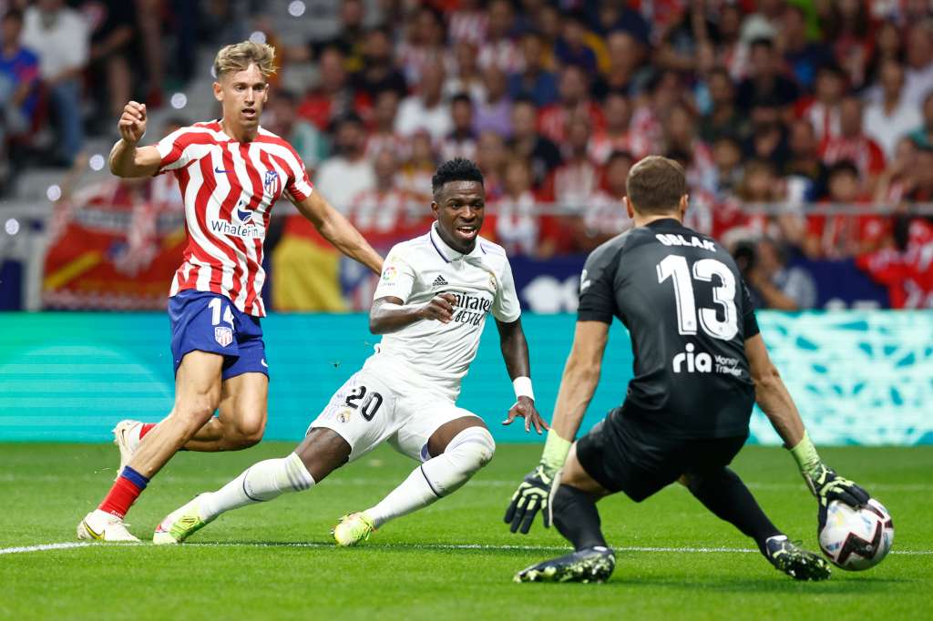 MADRID, 18/09/2022.- El delantero brasileño del Real Madrid, Vinicius Jr. (c), remata ante el guardameta esloveno del Atlético de Madrid, Jan Oblak, durante el encuentro correspondiente a la sexta jornada de primera división que disputan hoy Domingo en el estadio Metropolitano, en Madrid. EFE / Rodrigo Jiménez.