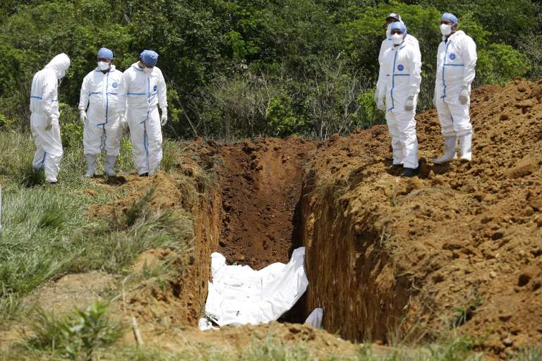 -FOTODELDÍA- AME3236. DAVID (PANAMÁ), 17/03/2023.- Trabajadores forenses realizan el entierro de los cuerpos de migrantes fallecidos durante un accidente en autobús el pasado mes de febrero, hoy en David (Panamá). El pasado 15 de febrero un autobús que trasladaba a 66 migrantes desde un albergue en la selvática provincia de Darién, en la frontera con Colombia, hasta otro similar en el norteño Chiriquí, limítrofe con Costa Rica, se accidentó causando la muerte de 37 migrantes y dos panameños, según los últimos datos oficiales. Los cuerpos que no han sido reclamados por sus familiares serán sepultados este viernes en David, capital de Chiriquí, cerca de donde ocurrió el accidente. EFE/ Bienvenido Velasco