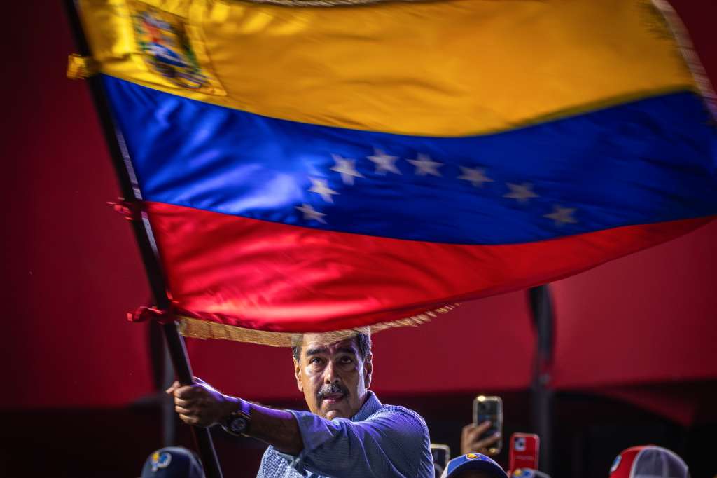 -FOTODELDÍA- AME4896. CARACAS (VENEZUELA), 25/07/2024.- El presidente de Venezuela y aspirante a la reelección, Nicolás Maduro, agita una bandera en el cierre de su campaña este jueves, en Caracas (Venezuela). Maduro aseguró que cuenta con una "nueva mayoría" que lo respaldará en los comicios de este domingo, en los que buscará una segunda reelección, para lo que deberá enfrentarse contra nueve contendientes. EFE/ Henry Chirinos