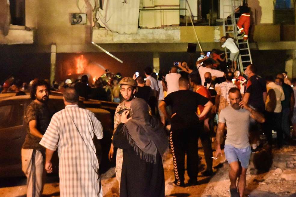 Personas son evacuadas de uno de los edificios afectados por el incendio.