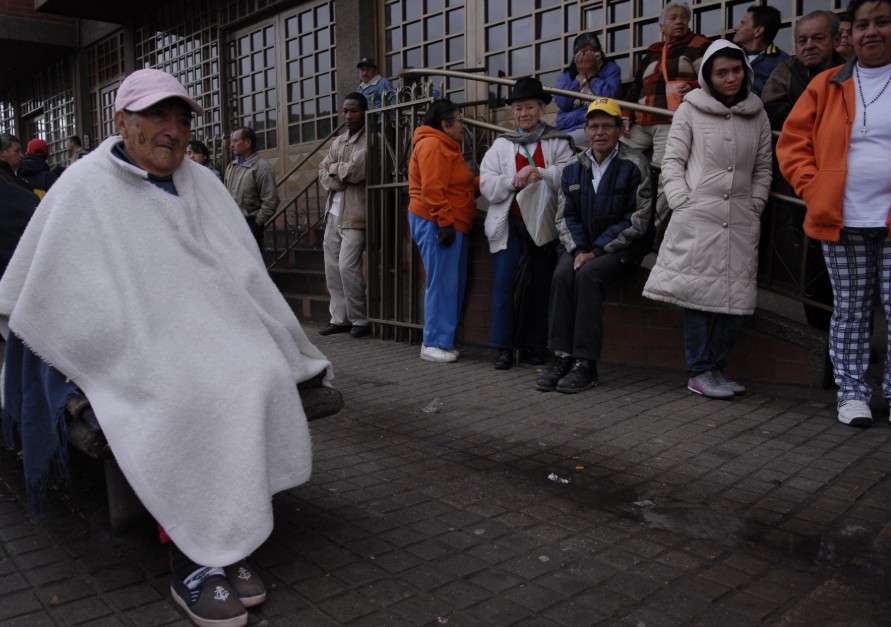 Grupo de pensionados haciendo fila en la calle