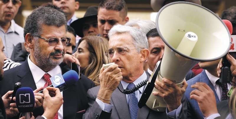 El expresidente y actual senador por el Centro Democrático, Álvaro Uribe (d), sostiene un megáfono mientras habla con los medios de comunicación acompañado por el abogado Jaime Granados (i) hoy, viernes 23 de febrero de 2018, a su llegada a la Corte Suprema de Justicia en Bogotá (Colombia), para atender un requerimiento por una investigación de manipulación de testigos