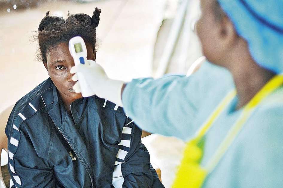 Una enfermera atiende a una paciente infectada con Ébola en Sierra Leona, uno de los países más golpeados por el virus durante 2014. / AFP