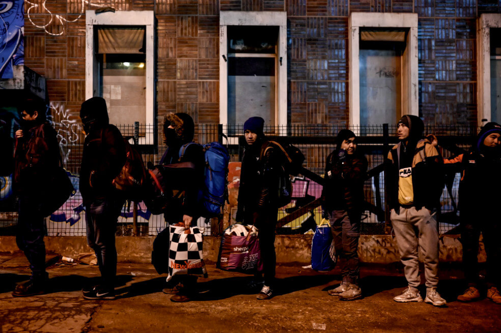 Los migrantes esperan ser evacuados por las fuerzas policiales temprano en la mañana del 28 de enero de 2020 en París. Entre 900 y 1800 personas vivían en esta área en tiendas de campaña. / AFP