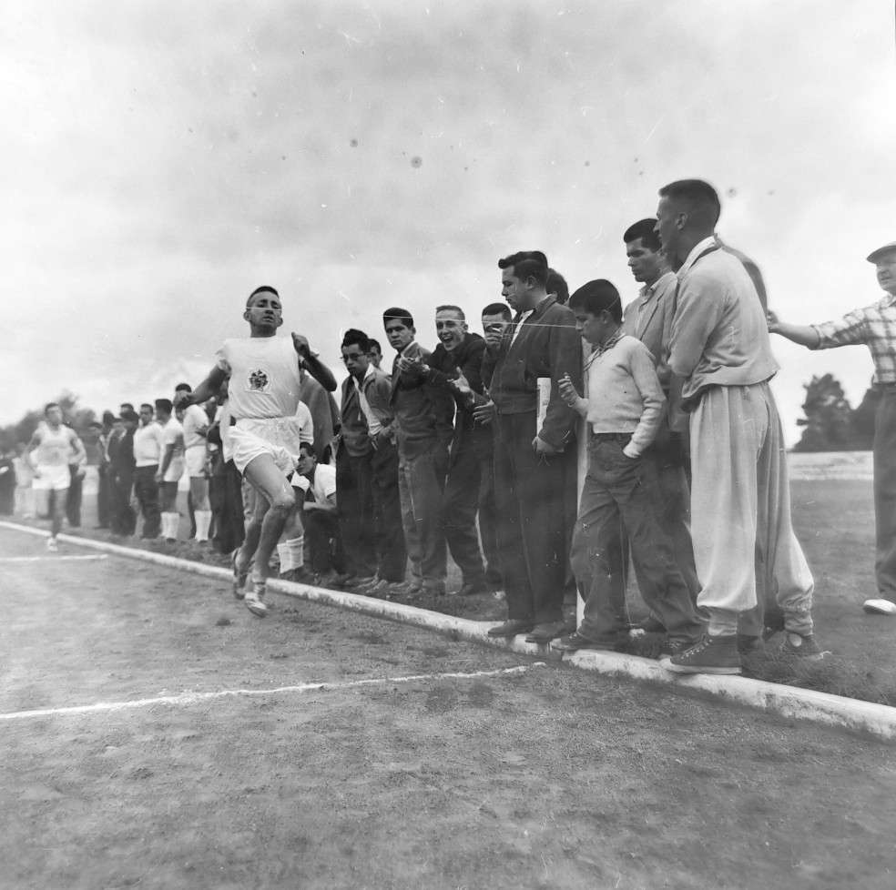 El atleta Harvey Borrero, con uniforme blanco, cruza triunfante la meta en una carrera celebrada en 1959.