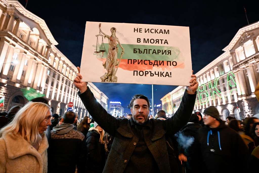 Un manifestante sostiene una pancarta que dice "No quiero sentencias a medida en mi Bulgaria" mientras participa en una manifestación antigubernamental en Sofía el 10 de diciembre de 2025.