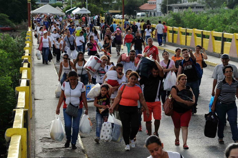 Venezolanos mientras retornaban a San Antonio de Táchira desde Cúcuta el pasado domingo, tras adquirir productos básicos que escasean en sus regiones. / AFP