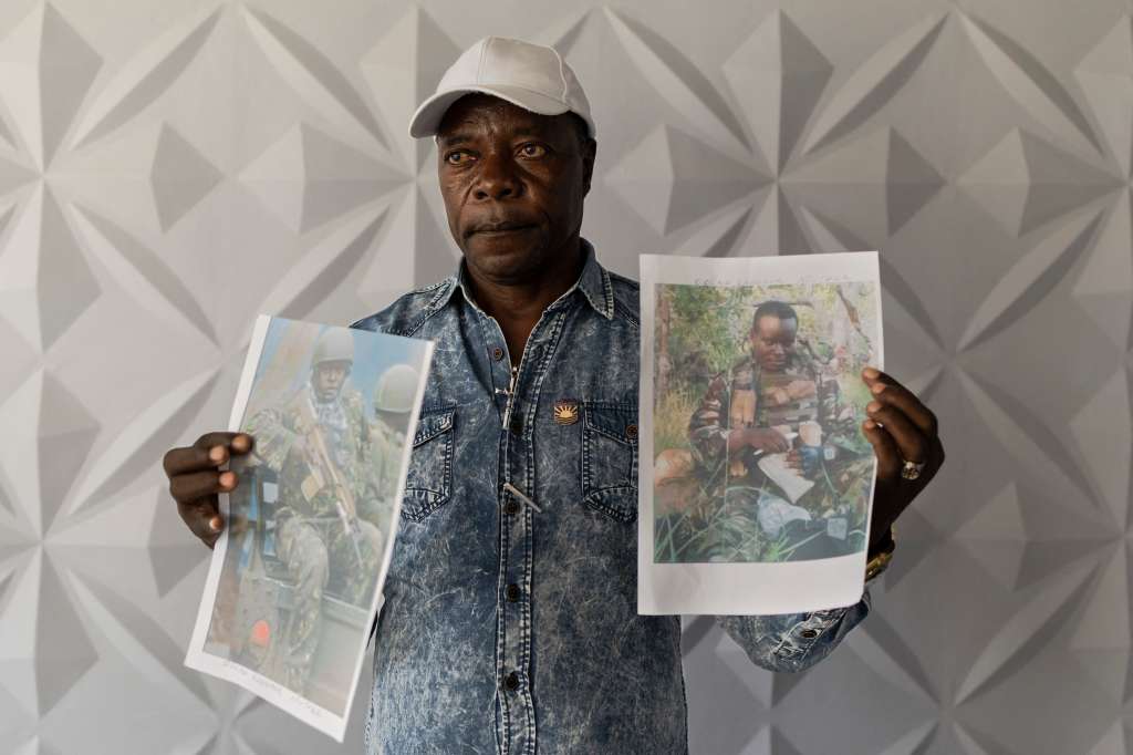 Charles Ojiambo Mutoka, de 72 años, posa con retratos de su hijo Oscar, quien se enteró de que fue asesinado en agosto en la guerra en Ucrania.