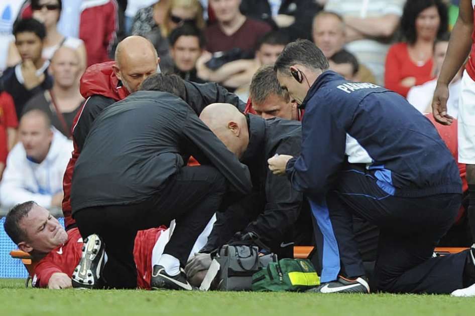 Wayne Rooney es atentido por el personal médico del Manchester United 