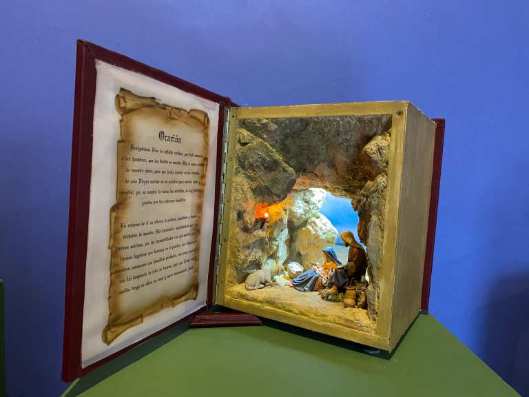 Esta vez, el homenaje especial es para el Niño Dios, protagonista del pesebre, de quien destacan su importancia y la trascendencia de su figura en las representaciones artísticas a través de la historia. Esta pieza se llama "El libro del nacimiento" y fue hecha por Gonzalo Suárez Velásquez.