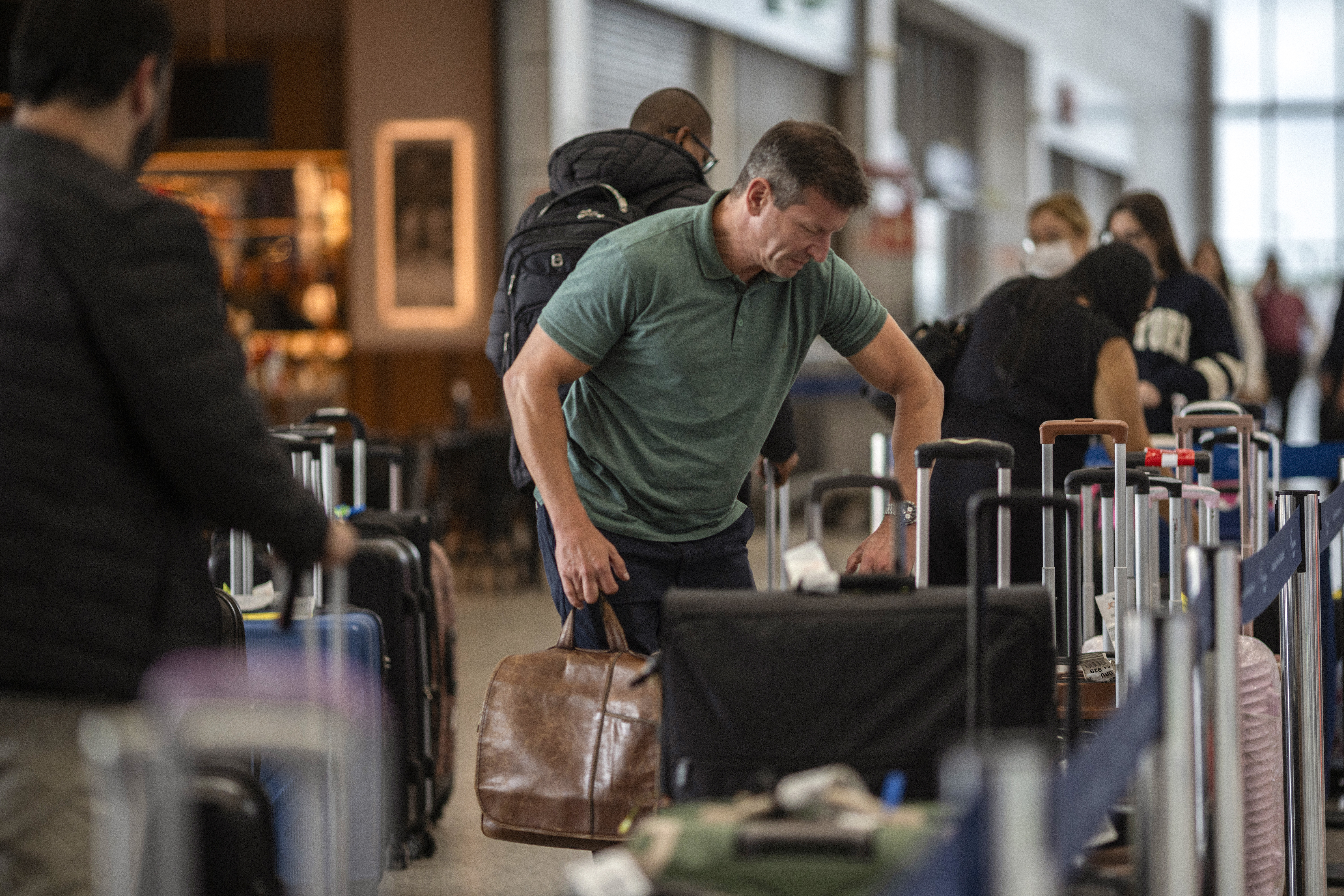 AME8629. PORTO ALEGRE (BRASIL), 18/10/2024.- Un hombre levanta su equipaje en las instalaciones del Aeropuerto Internacional Salgado Filho este viernes, en Porto Alegre (Brasil). El aeropuerto de la ciudad brasileña de Porto Alegre, uno de los mayores del país, volvió a operar este viernes más de cinco meses después de que unas devastadoras inundaciones cubrieran de agua la región sur de Brasil. EFE/ Daniel Marenco