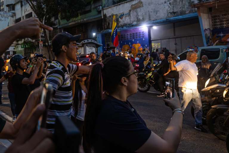 AME6008. CARACAS (VENEZUELA), 28/07/2024.- Seguidores del presidente de Venezuela y candidato a la reelección, Nicolás Maduro, se enfrentan desde una caravana de motocicletas con personas este domingo, en Caracas (Venezuela). Varias decenas de motorizados que se identificaron como chavistas llegaron a un centro de votación en Caracas, donde se encontraban testigos opositores y ciudadanos que esperaban el comienzo del escrutinio de las elecciones presidenciales de este domingo, lo que dio lugar a una confrontación que acabó a golpes, ante la mirada impasible de los policías, que no intervinieron para detener la pelea. EFE/ Henry Chirinos