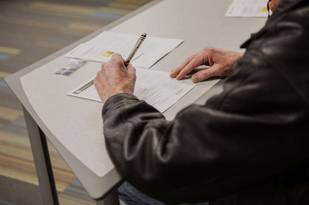 Un desempleado llena un formulario de solicitud durante un evento de reclutamiento del Servicio Postal de los Estados Unidos. / Bloomberg News