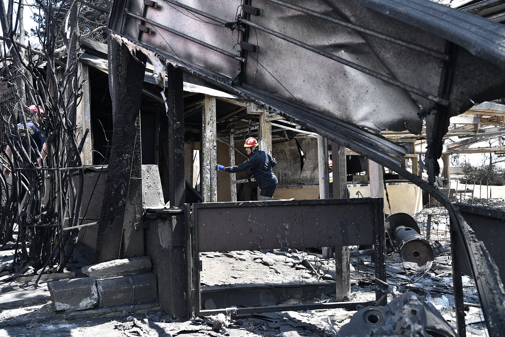 Bomberos investigan y recorren edificaciones afectadas por el incendio. / AFP