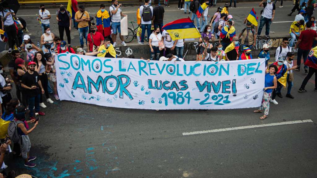 Los hermanos de Lucas Villa sostienen una pancarta en el mismo punto donde ocurrió el atentado.