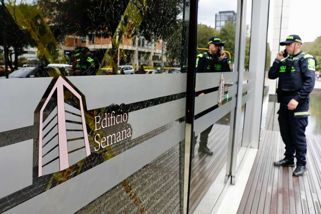 AME3569. BOGOTÁ (COLOMBIA), 29/09/2023.- Un integrante de la Policía permanece afuera del edificio donde funciona la revista Semana, hoy, en Bogotá (Colombia). Un grupo de indígenas entró este viernes a la fuerza a las instalaciones en Bogotá de la revista Semana, crítica del Gobierno colombiano, donde causaron destrozos en un vidrio de la entrada del edificio e intimidaron a las personas que allí se encontraban. Así lo denunció la directora de la revista, Vicky Dávila, quien aseguró que pidió ayuda a la Policía porque "un grupo grande de indígenas rompió vidrios en el edificio de Semana e ingresó a la fuerza". EFE/ Carlos Ortega