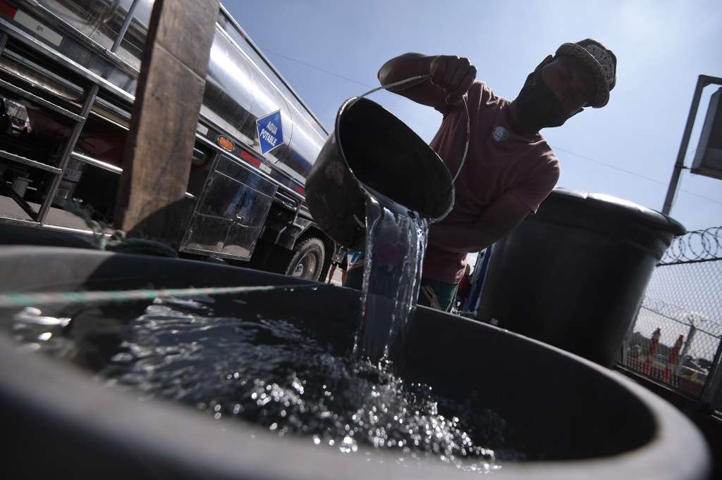 Bogotanos se abastecen de agua potable en carrotanques, tras la suspensión del servicio.