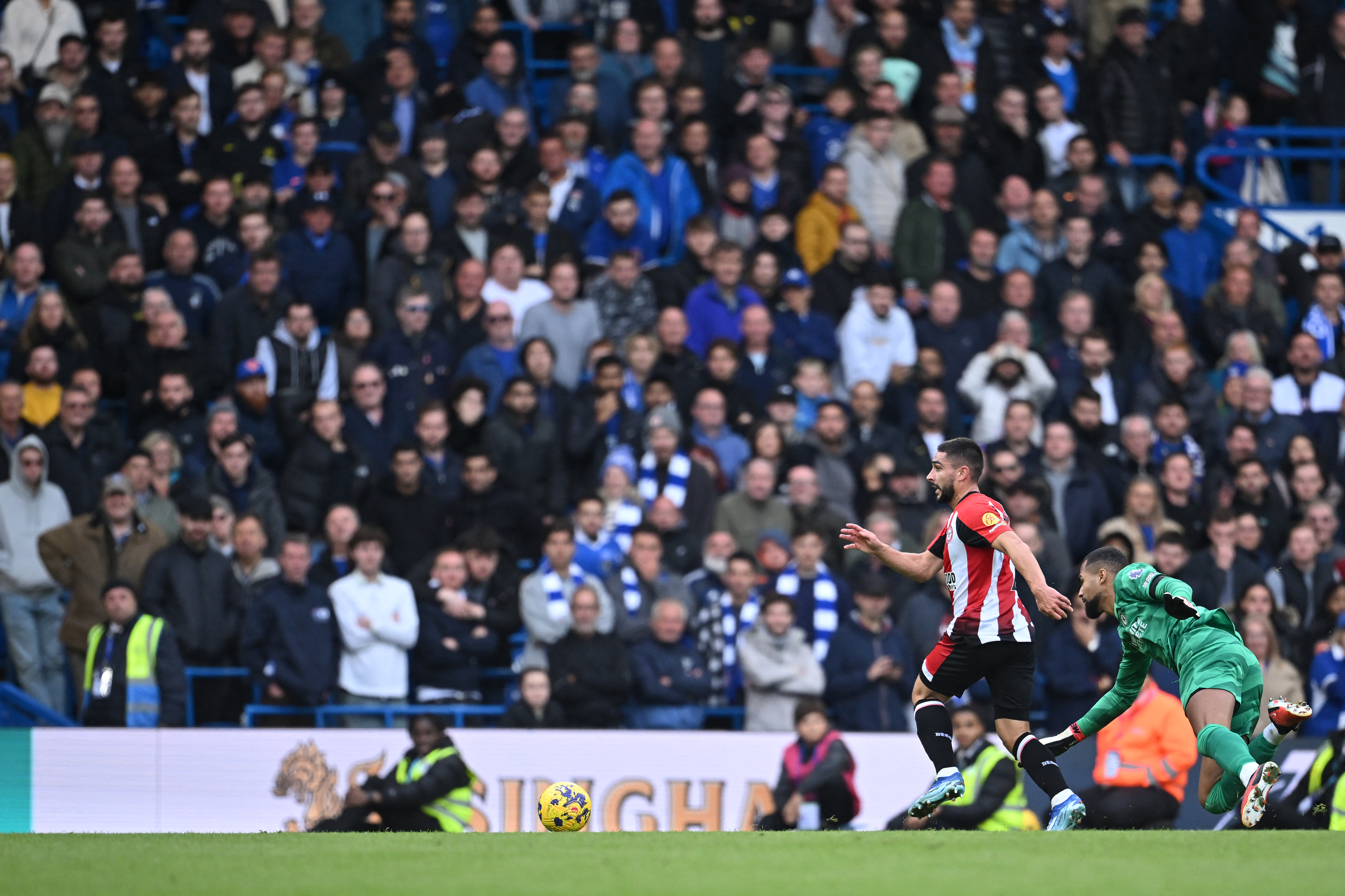 El delantero francés de Brentford #07 Neal Maupay (L) vence al portero español de Chelsea #01 Robert Sanchez para permitir que el delantero camerunés nacido en Francia de Brentford #19 Bryan Mbeumo (invisible) marque durante el partido de fútbol de la Premier League inglesa entre Chelsea y Brentford en Stamford Bridge en Londres el 28 de octubre de 2023. (Foto de JUSTIN TALLIS / AFP) / USO RESTRINGIDO A EDITORIAL. No se puede utilizar con audio, vídeo, datos, listas de partidos, logotipos de clubes/ligas o servicios "en vivo" no autorizados. Uso en línea durante el partido limitado a 120 imágenes. Se podrán utilizar 40 imágenes adicionales en el tiempo extra. Sin emulación de vídeo. Uso de redes sociales durante el partido limitado a 120 imágenes. Se podrán utilizar 40 imágenes adicionales en el tiempo extra. No se utiliza en publicaciones de apuestas, juegos o publicaciones de un solo club/liga/jugador. /