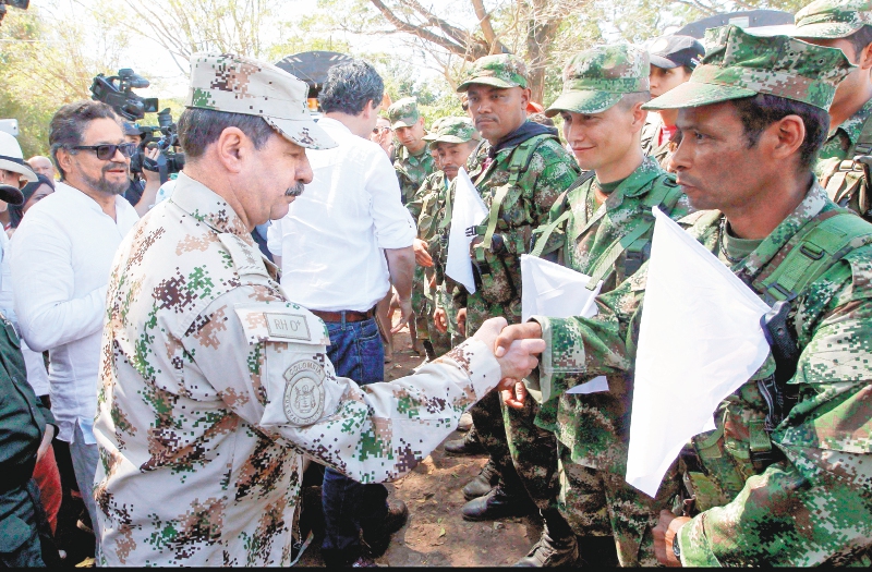 El general Javier Flórez saluda a un grupo de guerrilleros de las Farc durante la movilización de los combatientes hacia las zonas veredales donde se concentrarían para hacer la dejación de armas. / EFE