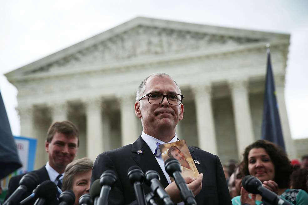 Jim Obergefell da declaraciones mientras sostiene una foto de su difunto esposo, John Arthur. 