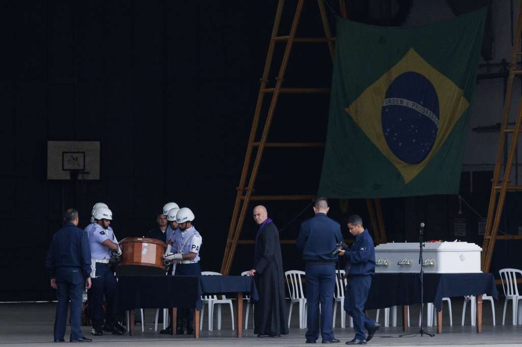AME017. GUARULHOS (BRASIL), 13/08/2024.- Integrantes de la Fuerza Aérea de Brasil cargan un ataúd con los restos de una víctima del accidente aéreo de un avión de la aerolínea Voepass, este martes en la Base Militar en Guarulhos (Brasil). Un avión militar KC-390 Millennium de la Fuerza Aérea Brasileña transporte los restos de varias víctimas del accidente aéreo del pasado viernes, en el que murieron 62 personas, al municipio de Cascavel, de donde partió el vuelo. EFE/ Isaac Fontana