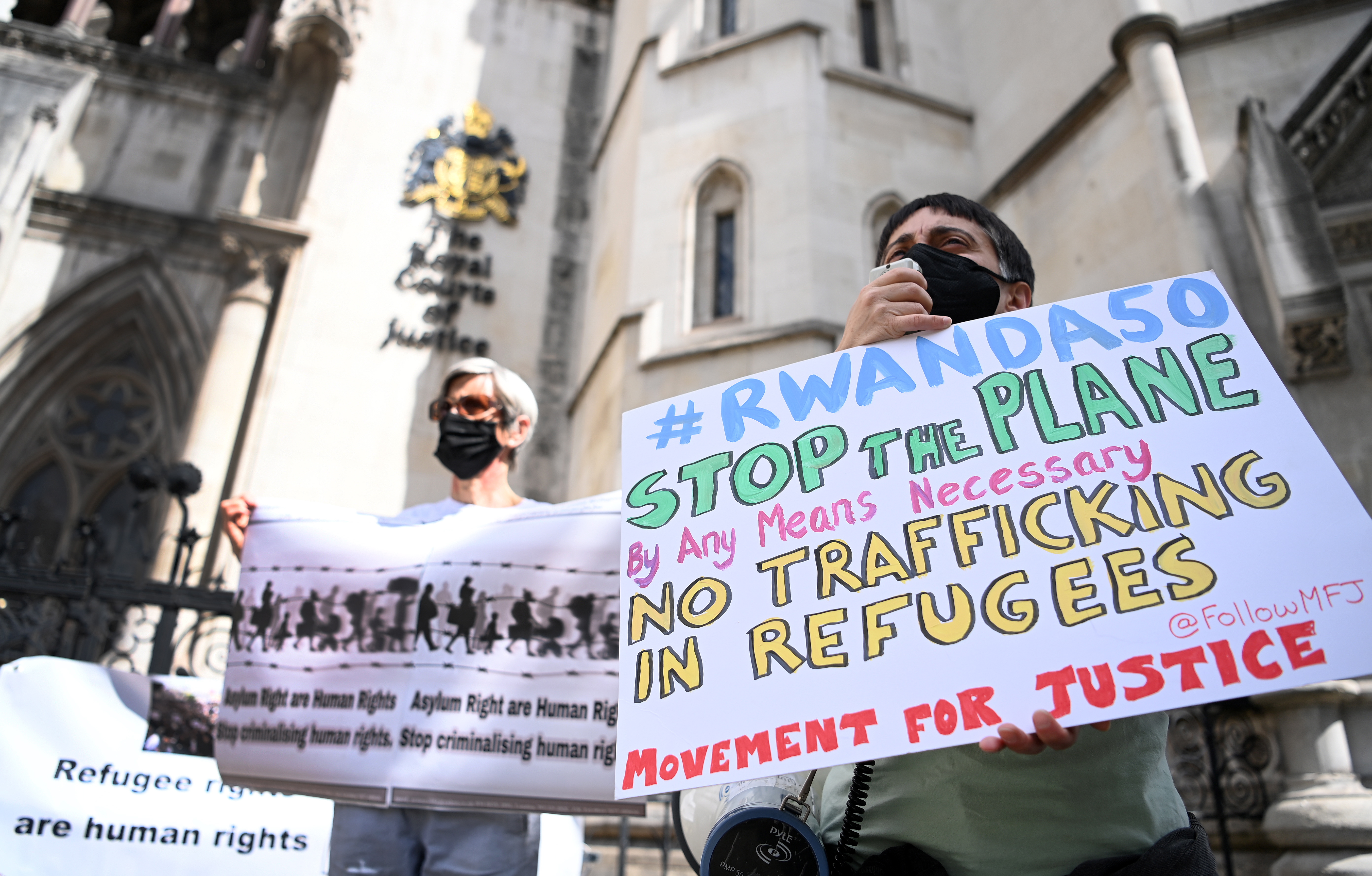 London (United Kingdom), 13/06/2022.- Human rights activists protest against the British government'Äôs migrant policy, outside the High Court in London, Britain, 13 June 2022. Campaigners are appealing against a scheme designed to crack down on migrants that intends to provide those deemed to have arrived unlawfully with a one-way ticket to Rwanda. Some thirty people are due to be flown to the African country on 14 June, if the High Court rules against the appeal. (Protestas, Ruanda, Reino Unido, Londres) EFE/EPA/ANDY RAIN