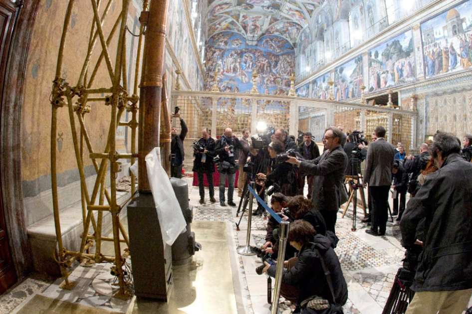Reporteros gráficos toman fotos de las estufas dentro de la Capilla Sixtina del Vaticano.