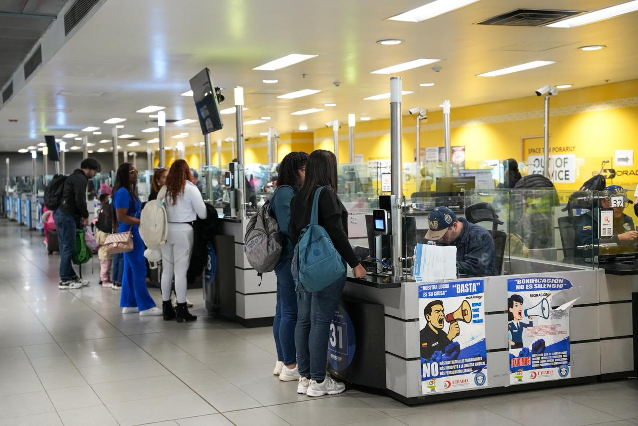 Personas al frente de un punto de atención de Migración Colombia, un paso necesario para la revisión de documentos.