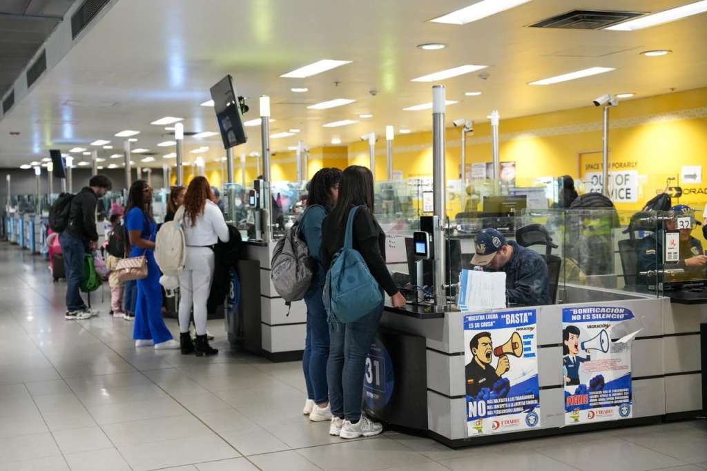 Personas al frente de un punto de atención de Migración Colombia, un paso necesario para la revisión de documentos.