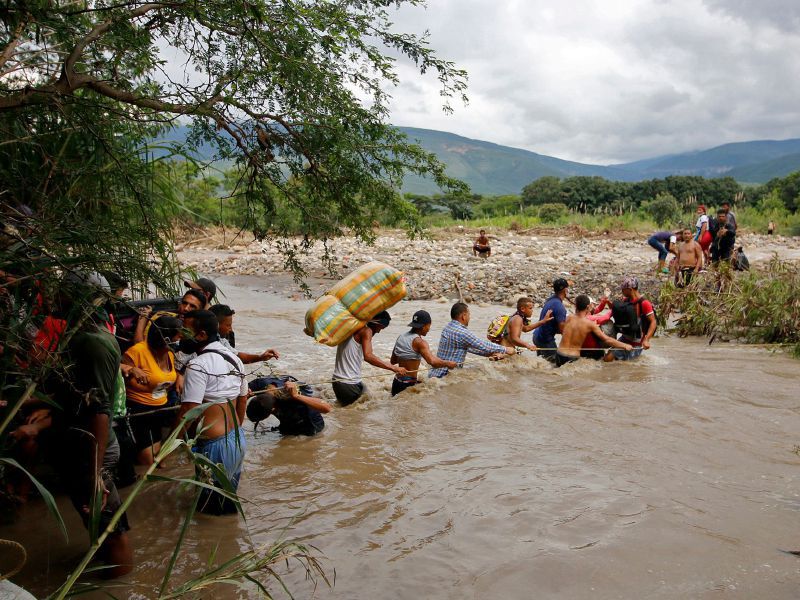 Migrantes venezolanos cruzaron el río Táchira, en la frontera con Colombia, para dejar su país; usan esta vía por cuenta del cierre del paso fronterizo. / AFP