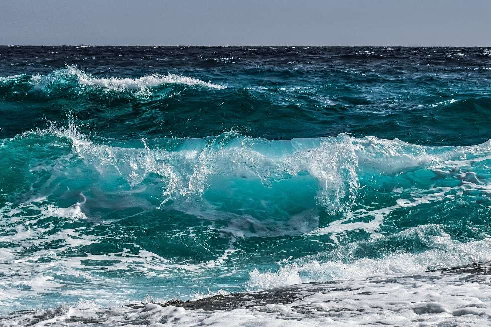 Olas del mar. El color del agua es azul claro. Las olas golpean sobre la playa.