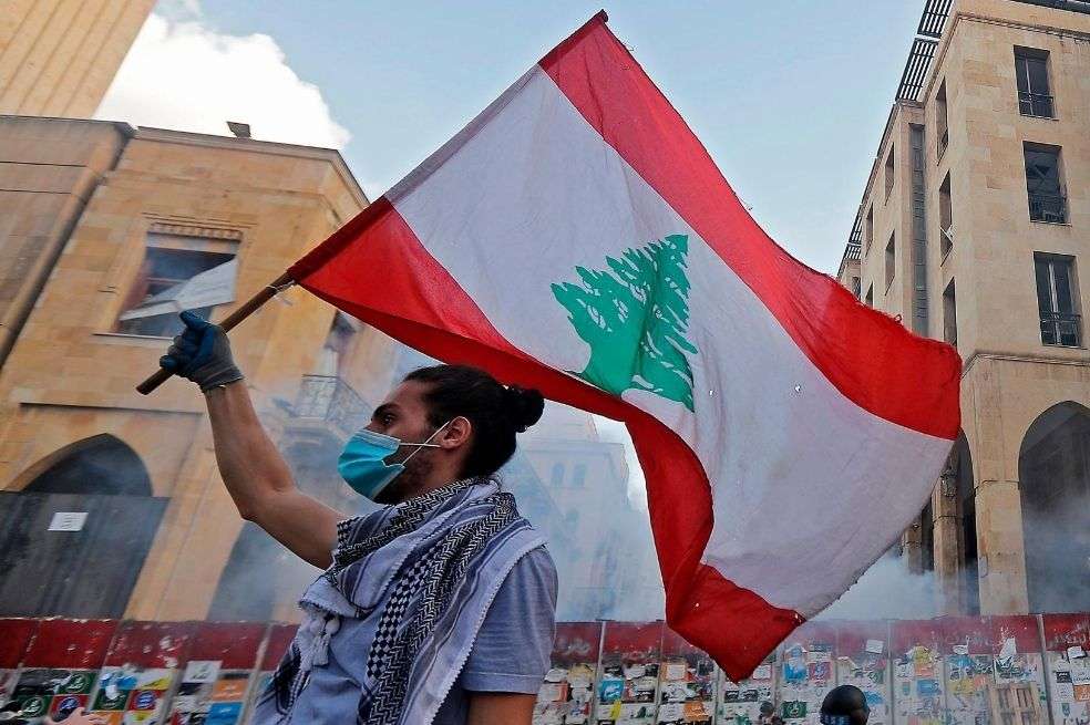 Un manifestante libanés ondea una bandera nacional en medio de enfrentamientos con las fuerzas de seguridad en el centro de Beirut.