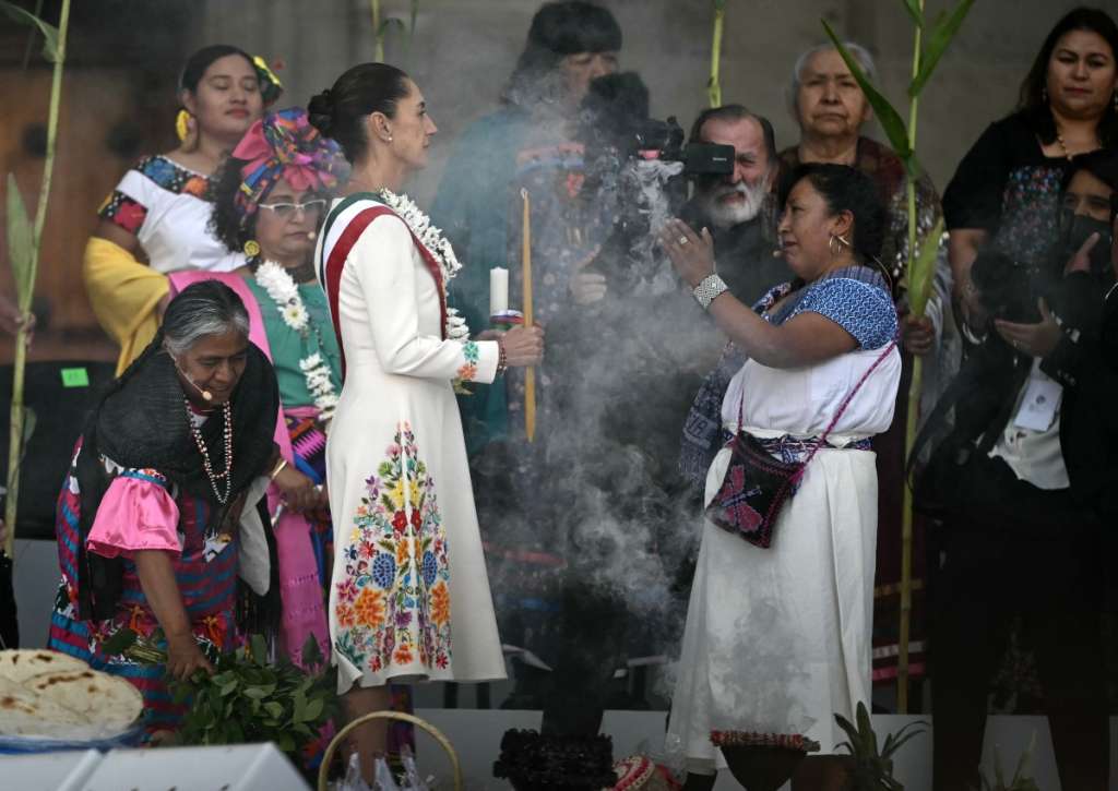 (FILES) Mexico's new President Claudia Sheinbaum (L) takes part in a ceremony in which she receives a ceremonial staff from indigenous people at the Zocalo Square in Mexico City on October 1, 2024.