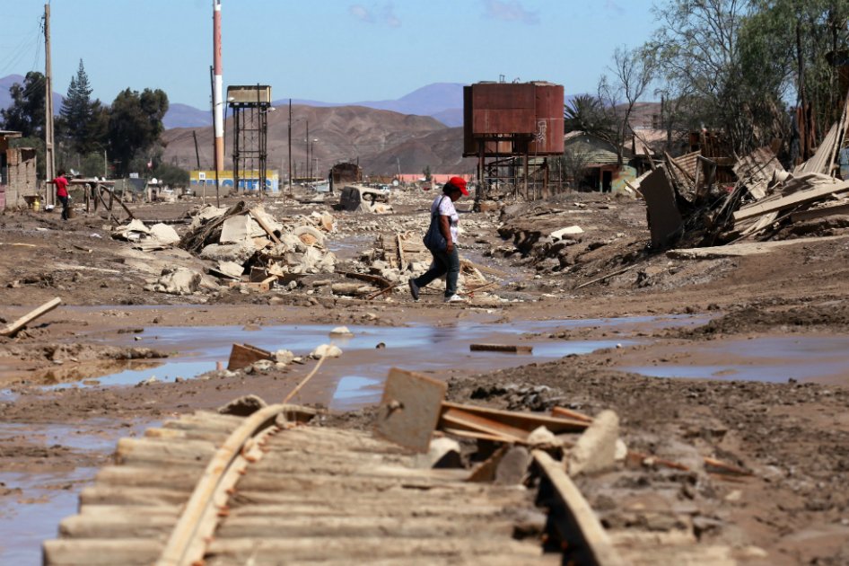 Una mujer cruza por una vía férrea tras las inundaciones en la localidad Diego de Almagro a 1000 kilómetros al norte de Santiago de Chile. / EFE