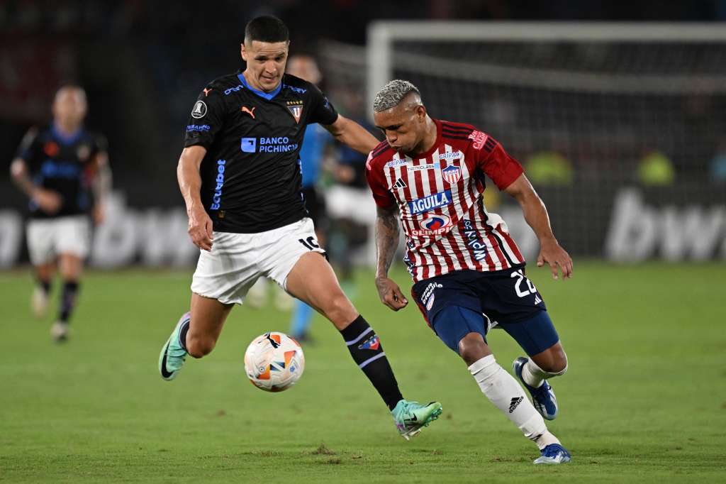 Liga de Quito's Paraguayan forward Alex Arce (L) is challenged by Junior's defender Jermein Peña during the Copa Libertadores group stage first leg football match between Colombia's Junior and Ecuador's Liga de Quito at the Metropolitano Roberto Melendez Stadium in Barranquilla, Colombia, on April 23, 2024.