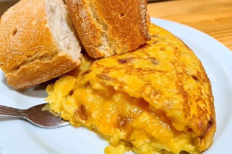 Cuando alcance la textura deseada, voltee: se debe poner un plato grande sobre la sartén, luego se da vuelta a la tortilla sobre el plato y se devuelve a la sartén dejándola resbalar por el lado que no ha cocinado. / Cortesía Harry Sasson