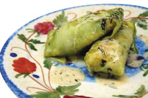 Rollos de repollo rellenos de arroz, camarón y frutos secos con salsa de cilantro