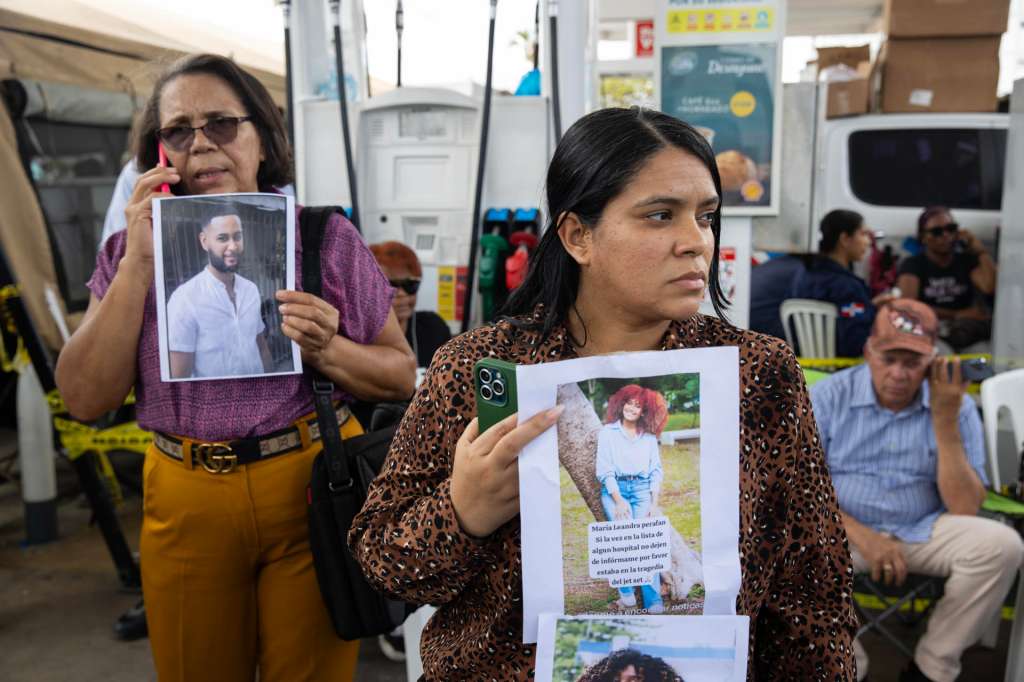FOTODELDÍA AME7332. SANTO DOMINGO (REPÚBLICA DOMINICANA), 09/04/2025.- Mujeres esperan información sobre sus familiares a las afueras de la discoteca Jet Set este miércoles, en Santo Domingo (República Dominicana). La cifra de muertos tras el desplome la madrugada de ayer del techo de una discoteca en Santo Domingo se eleva a 136 y podría aumentar, según datos ofrecidos por uno de los responsables del trabajo de los socorristas. EFE/ Orlando Barría
