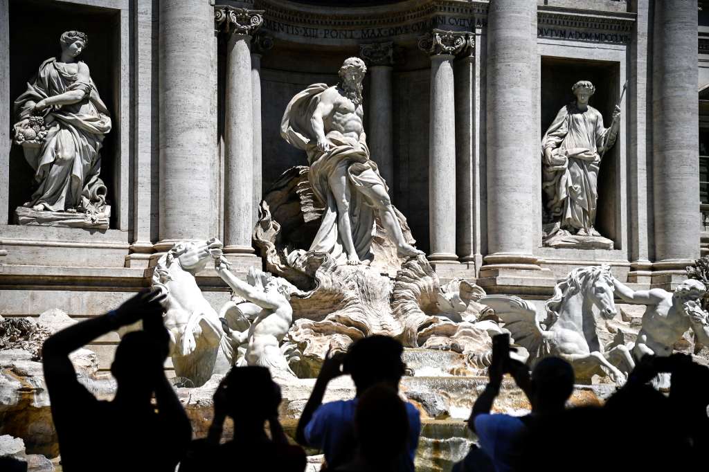 Roma (Italia), 07/06/2024.- Turistas toman fotografías mientras visitan la Fontana de Trevi (siglo XVIII), este viernes en Roma, Italia.-EFE/ Riccardo Antimiani