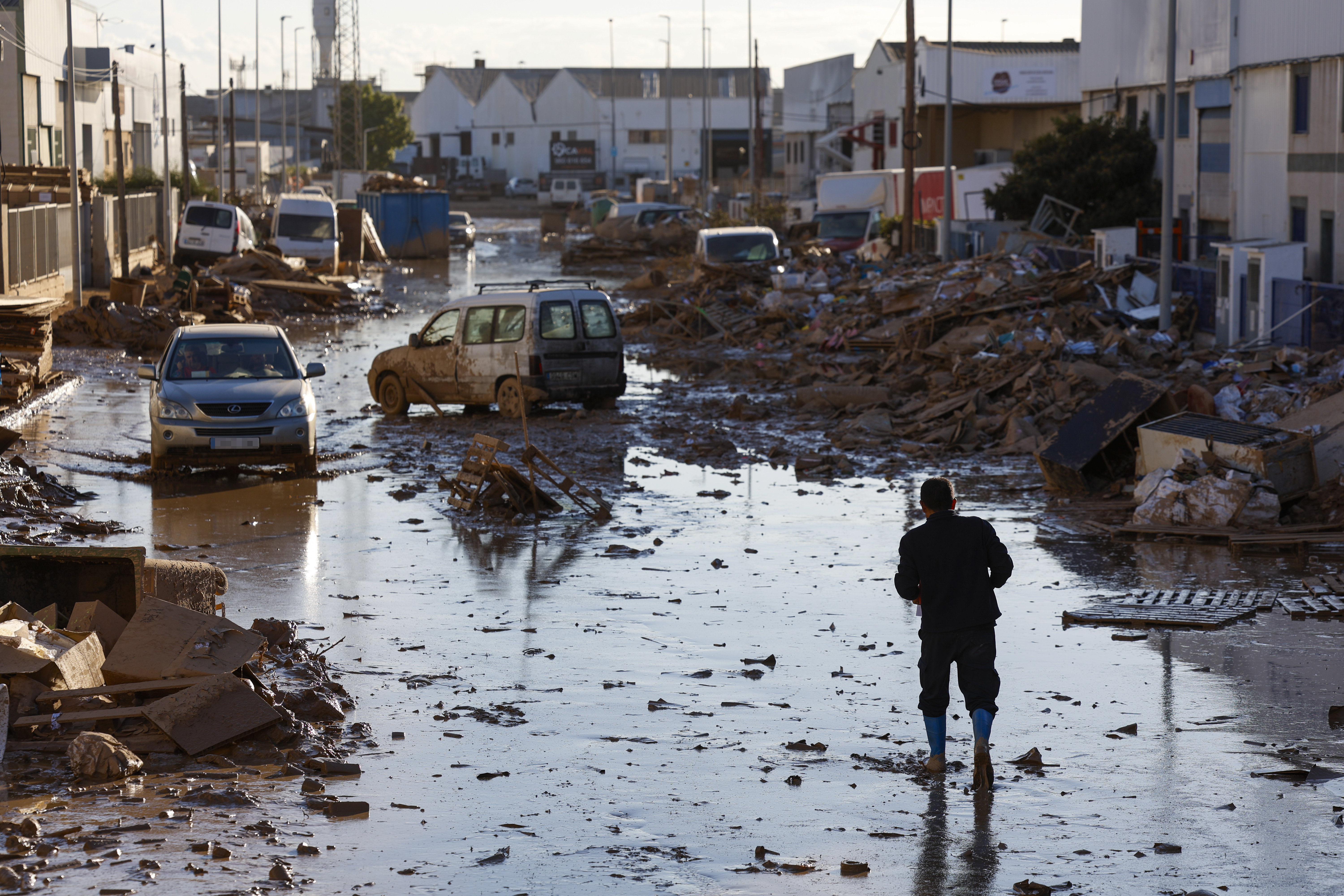 FOTODELDÍA CATARROJA (VALENCIA), 11/11/2024.- Una persona camina por una calle del polígono de Catarroja, este lunes. La última actualización de datos oficiales sobre los efectos de la dana y las devastadoras inundaciones del pasado 29 de octubre ha elevado a 222 el número de víctimas mortales confirmadas en toda España, y ha situado en 36.803 el número de personas que han sido rescatadas, 82 de ellas en las últimas horas. EFE/Jorge Zapata