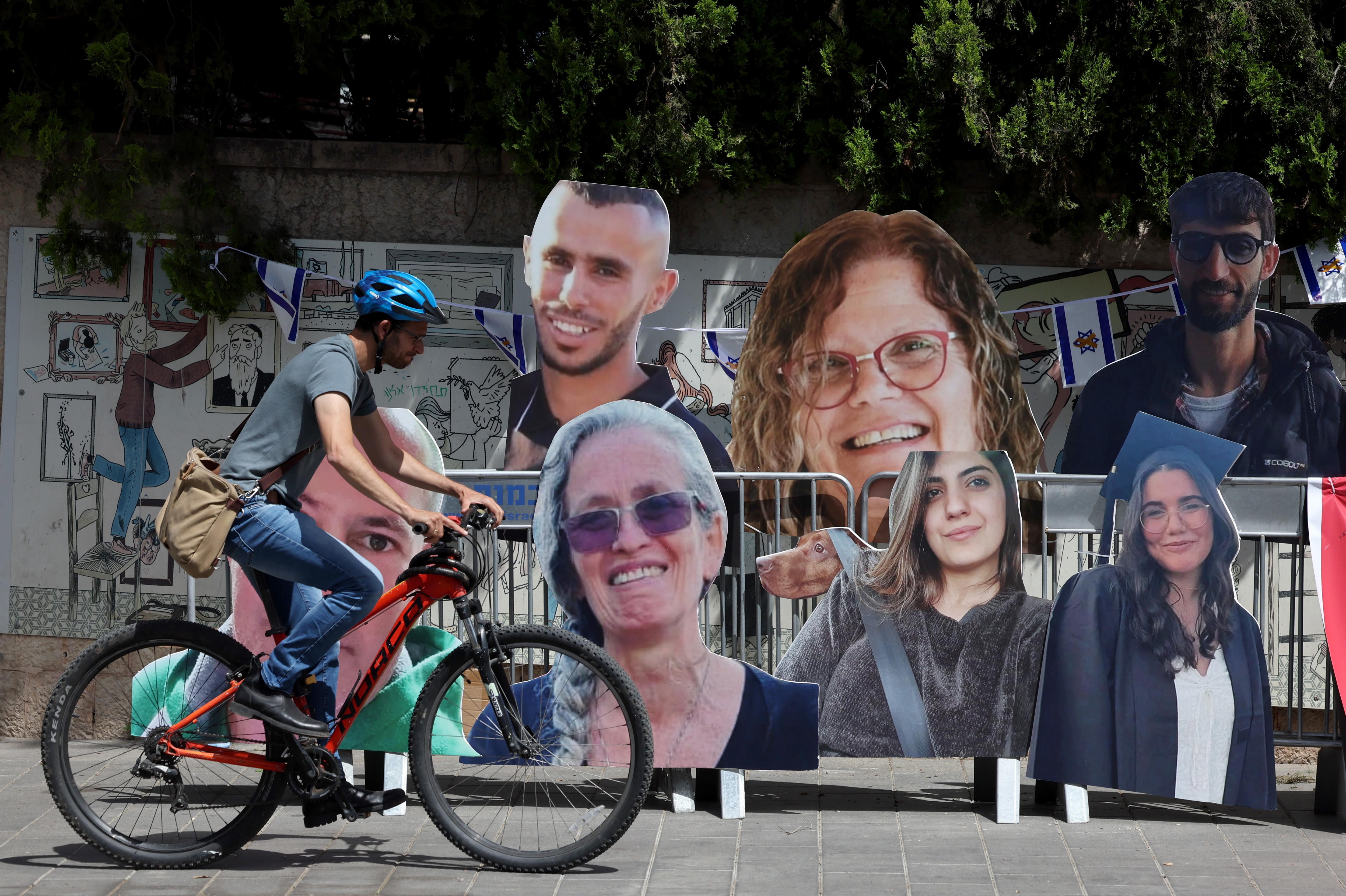 Jerusalem (-), 23/05/2024.- Man rides a bike by pictures of Israeli hostages held by Hamas in Gaza outside the residence of the Israeli Prime Minister Benjamin Netanyahu, in Jerusalem, 23 May 2024. According to the Israeli defense forces, 128 Israelis hostages are still held by Hamas in Gaza. More than 35,000 Palestinians and over 1,400 Israelis have been killed, according to the Palestinian Health Ministry and the Israel Defense Forces (IDF), since Hamas militants launched an attack against Israel from the Gaza Strip on 07 October 2023, and the Israeli operations in Gaza and the West Bank which followed it. (Protestas, Jerusalén) EFE/EPA/ABIR SULTAN