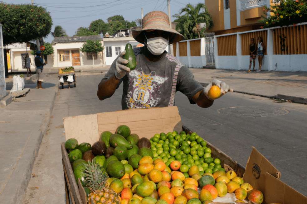 Un hombre vende frutas pese a las restricciones impuestas para prevenir el contagio de Covid-19 este martes en Cartagena. / EFE