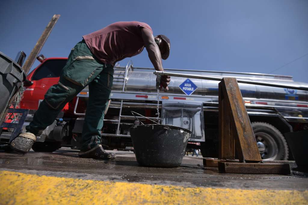 Bogotanos se abastecen de agua potable en carrotanques, tras la suspensión del servicio.