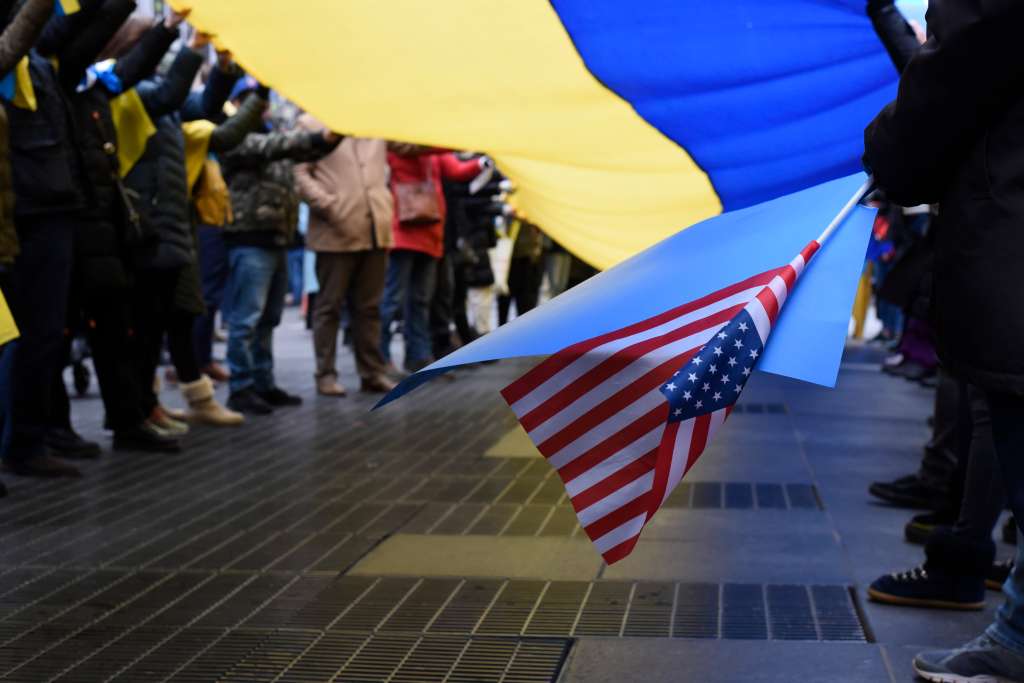 New York (United States), 24/02/2022.- An attendee holds an American flag while moving part of the Ukrainian flag with others during the Stop Putin' rally at Times Square in New York, New York, USA, 24 February 2022. Russian troops launched a major military operation on Ukraine on 24 February, after weeks of intense diplomacy and the imposition of Western sanctions on Russia aimed at preventing an armed conflict in Ukraine. (Protestas, Rusia, Ucrania, Estados Unidos, Nueva York) EFE/EPA/SARAH YENESEL