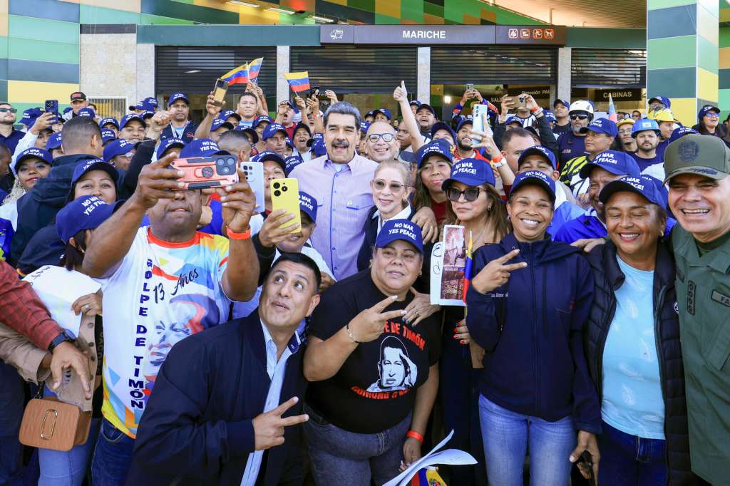 AME9511. CARACAS (VENEZUELA), 18/12/2025.- Fotografía cedida por el Palacio de Miraflores del presidente de Venezuela, Nicolás Maduro (c), junto a simpatizantes en un acto de gobierno este jueves, en Caracas (Venezuela). Maduro pidió al pueblo de Estados Unidos "levantar las banderas de la paz", en medio de las crecientes tensiones entre ambos países, tras el anuncio del presidente Donald Trump de bloquear los buques petroleros sancionados que se desplacen desde y hacia el país suramericano. EFE/ Palacio de Miraflores /SOLO USO EDITORIAL/NO VENTAS/ SOLO DISPONIBLE PARA ILUSTRAR LA NOTICIA QUE ACOMPAÑA (CRÉDITO OBLIGATORIO)