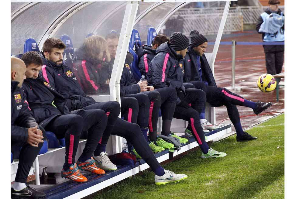 Una absoluta rereza: Alves (d), Messi (2i) y Piqué (3i) en el banquillo, durante un partido del Barcelona contra la Real Sociedad, años atrás. EFE/Javier Etxezarreta
