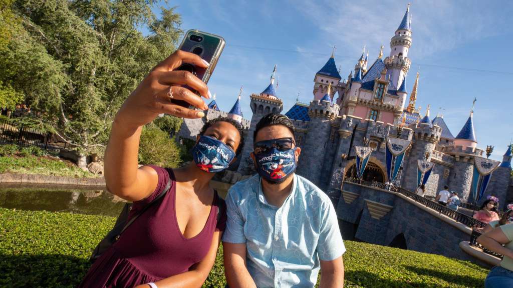 Fotografía cedida por Disneyland Resort donde una pareja se toma una selfie en frente del palacio de la Bella Durmiente en Disneyland Park en Anaheim, California.