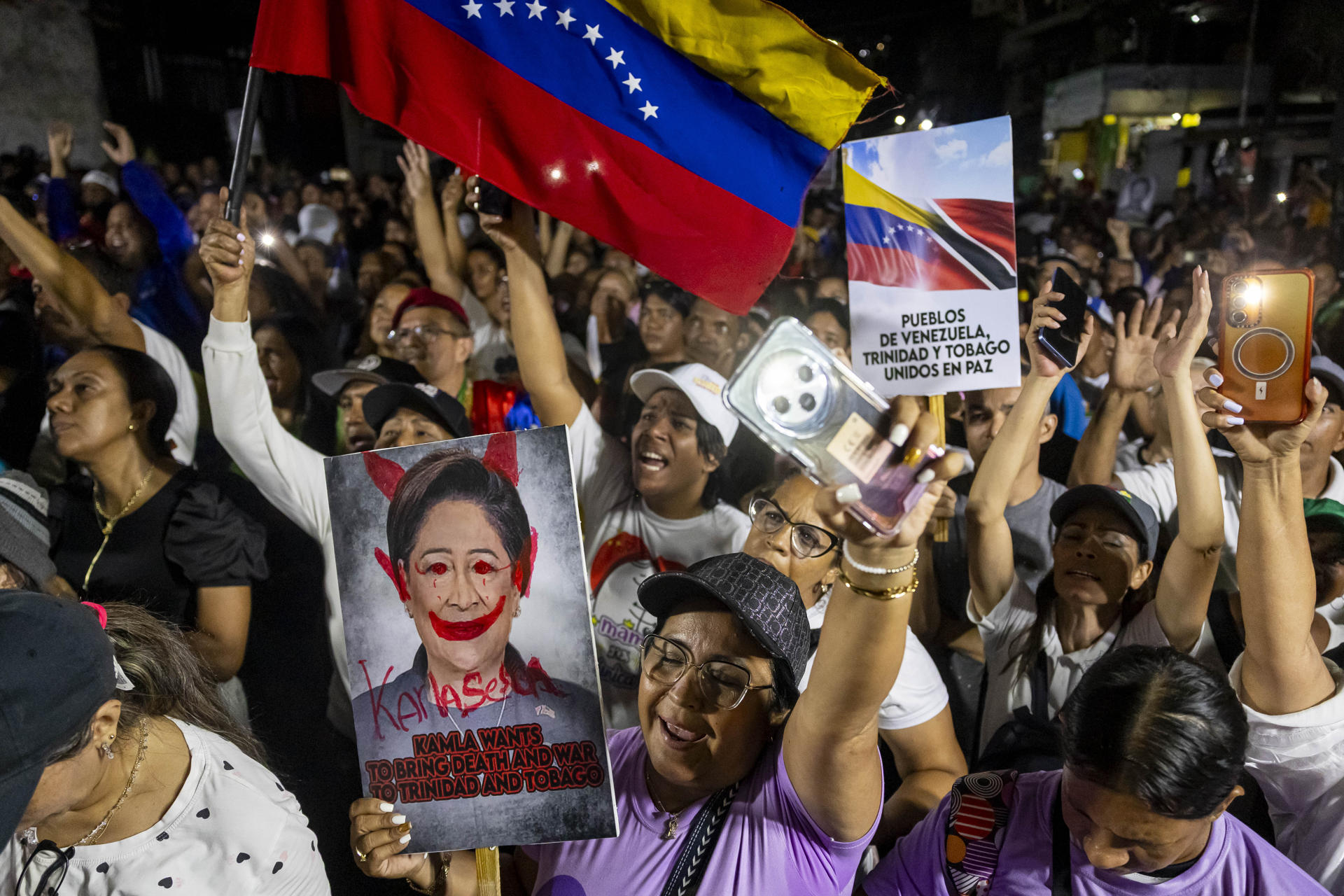 AME2962. CARACAS (VENEZUELA), 28/10/2025.- Personas sostienen carteles con la imagen de la primera ministra de Trinidad y Tobago, Kamla Persad-Bissessar, durante una manifestación este martes, en Caracas (Venezuela). Chavistas marcharon en defensa de la soberanía de Venezuela y en contra de la primera ministra de Trinidad y Tobago, luego de que ese vecino país insular recibiera el domingo un destructor de la Armada de EE.UU. para ejercicios militares, en medio del despliegue estadounidense en el Caribe. EFE/ Miguel Gutiérrez
