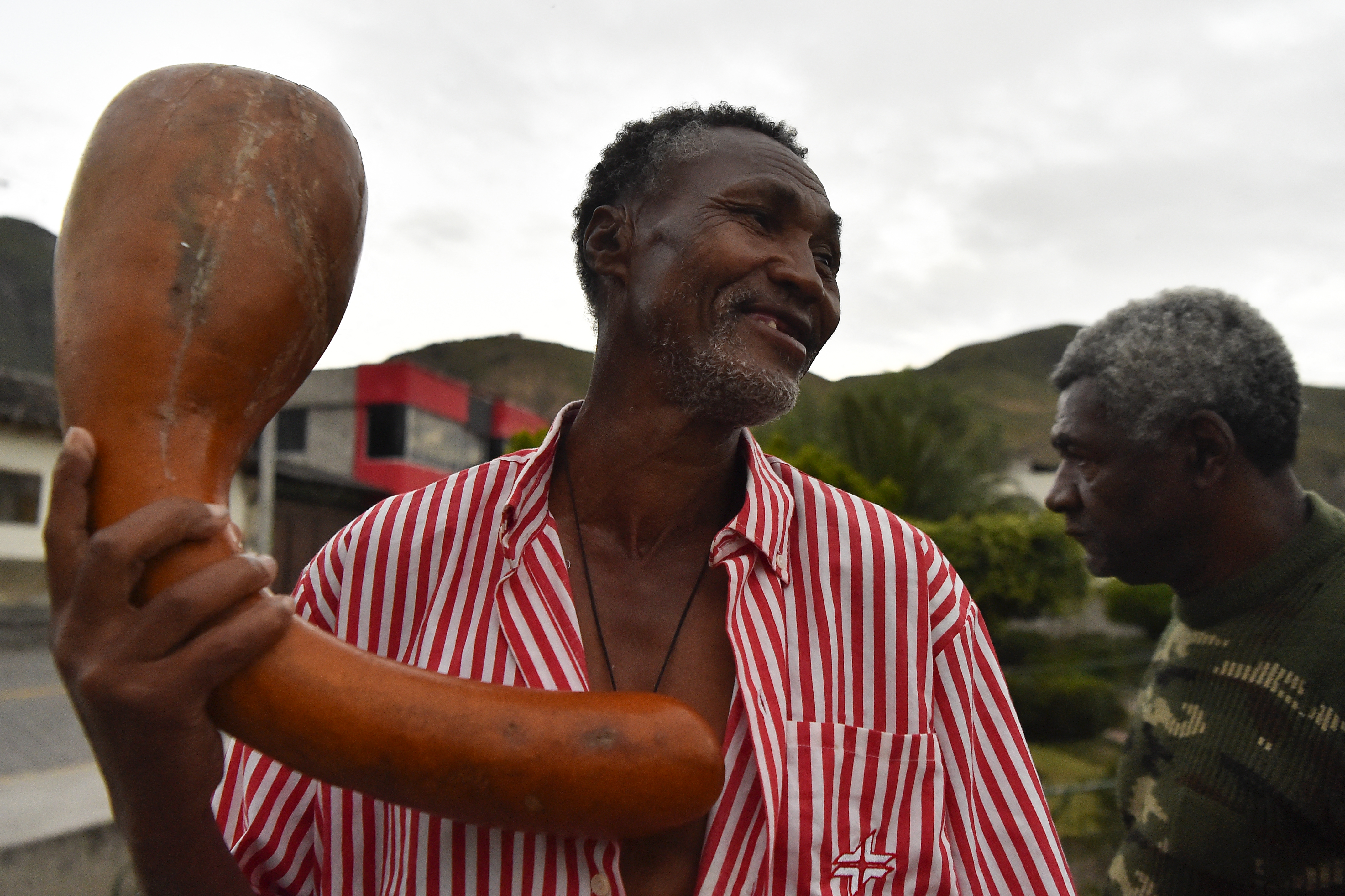 Campo Elias Rea (L) and Segundo Yepez, members of the "Mocha band", are seen at sunrise in the central park of Chalguayacu, Ecuador on December 4, 2021. - The "Mocha band" of Chalguayacu is a traditional musical group that uses leaves and gourds as instruments and participates in the festivities of San Francisco Javier, patron saint of Chalguayacu, a black village in the province of Imbabura in northern Ecuador. (Photo by Rodrigo BUENDIA / AFP)